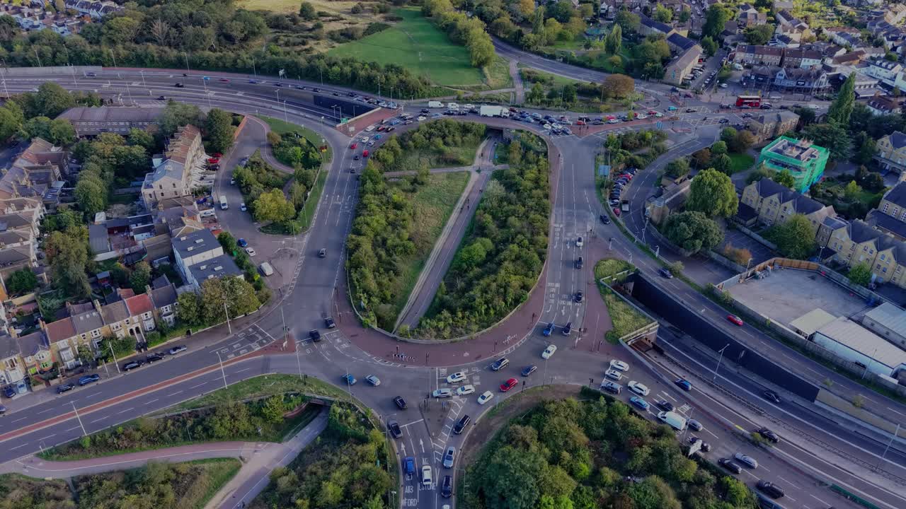 Aerial hyperlapse of the Green Man Roundabout, Leytonstone, London. Drone orbits, creating a clockwise rotating effect as long afternoon shadows, passing clouds, and sunlight play across the scene