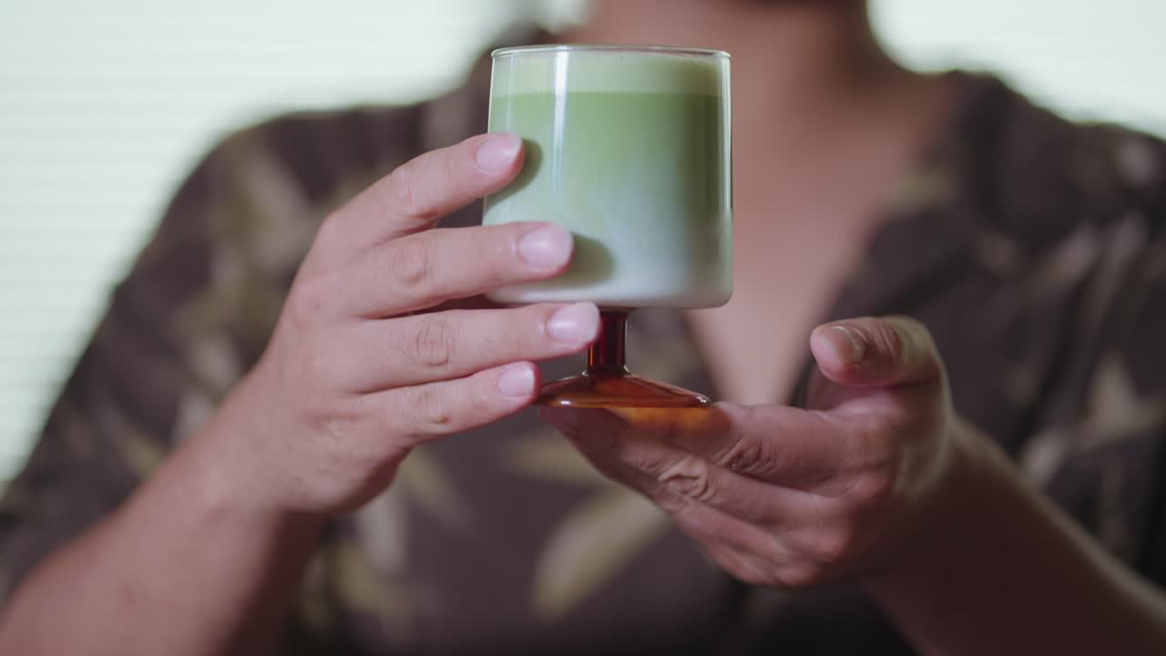 Person holding a matcha latte