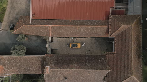 aerial top view of yellow car in old courtyard