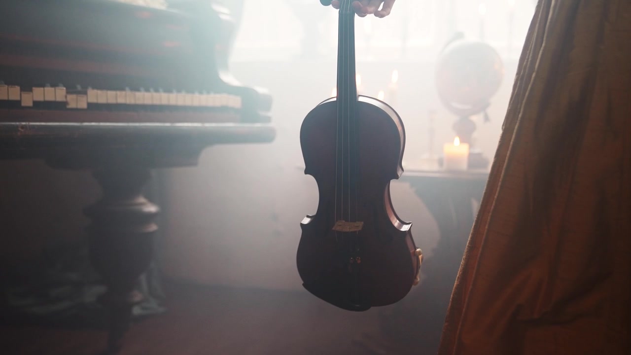 Una mano abbassa un violino in una stanza classica e suggestiva con pianoforte