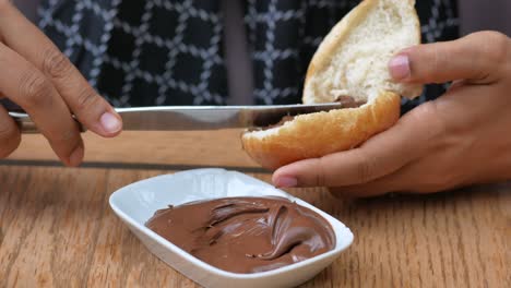 person spreading chocolate spread on bread