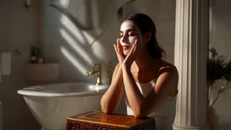 woman practicing self-care with a face mask in a luxurious bathroom