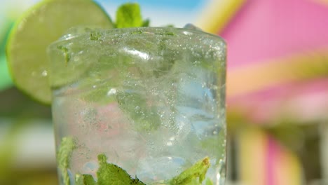 inclinación de cóctel de mojito en vidrio alto con fondo colorido