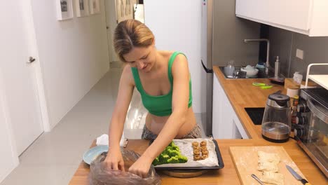 woman cooking broccoli and dumplings in kitchen