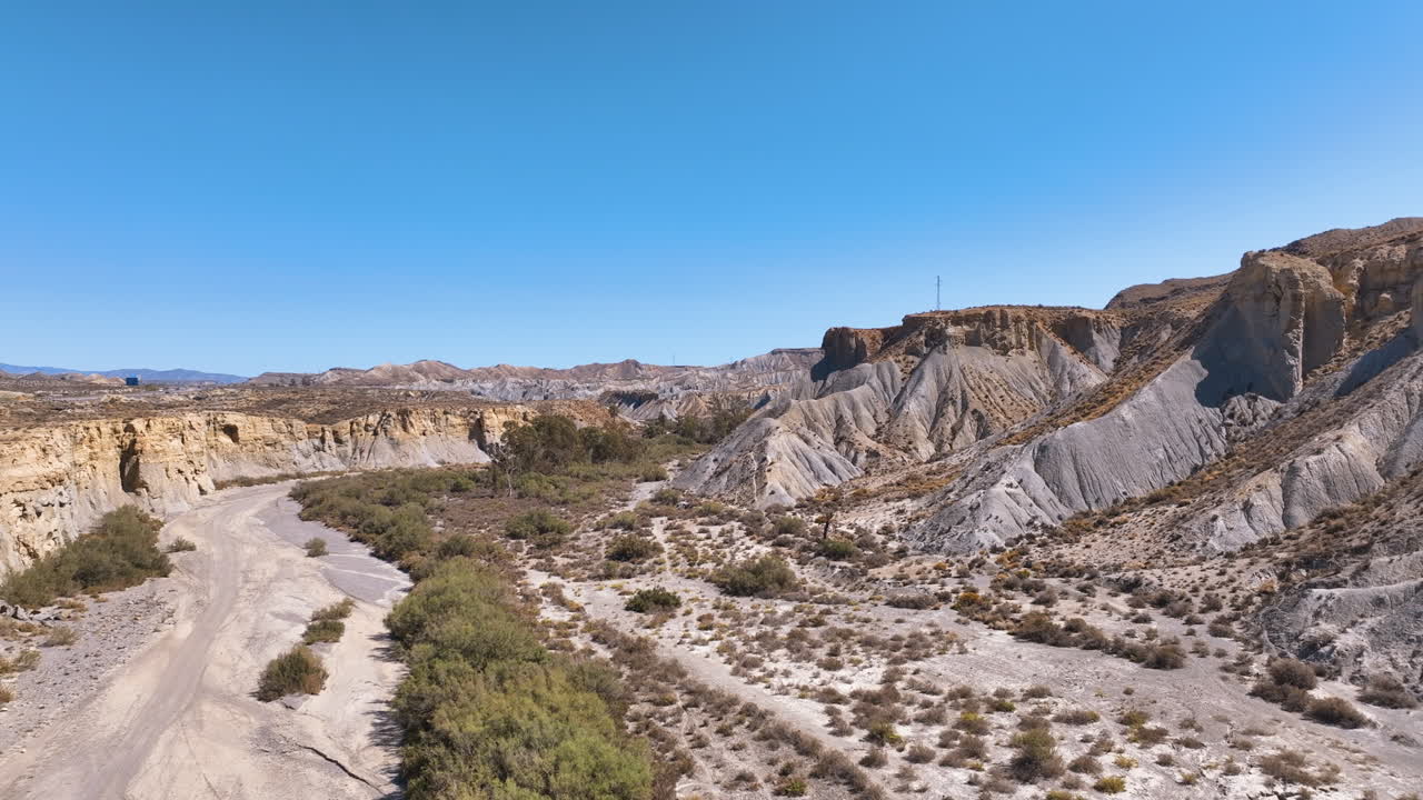 Aerial over badlands valley to famed Oasis of Lawrence of Arabia film location