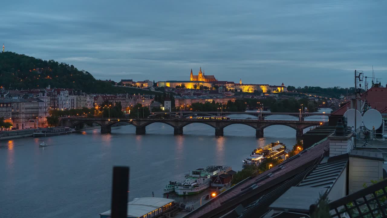 황혼에 옥상에서 블타바 강을 가로지르는 프라하 성과 교량의 시간 경과