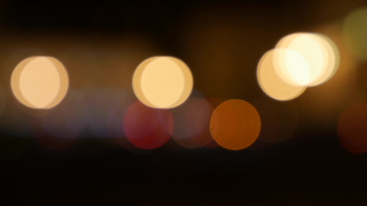 hermoso bokeh brillante en el fondo oscuro borroso por la noche. el redondo bokeh colorido brilla de las luces de los coches en la calle de la ciudad. fuera de foco con borroso. luces de la ciudad sin enfoque. bokeh de tráfico. concepto abstracto