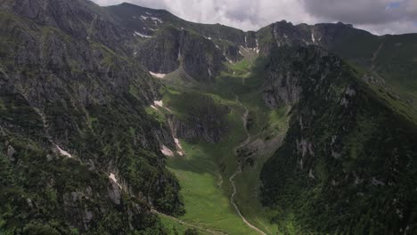 lush malaiesti valley in bucegi mountains with vibrant green slopes and trails, aerial view