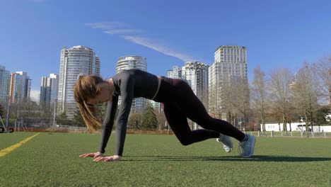 una joven atlética en forma entrenando en un tablón de parque eleva la rodilla