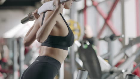 Strong-woman-doing-squat-exercise-with-barbell-in-fitness-center.