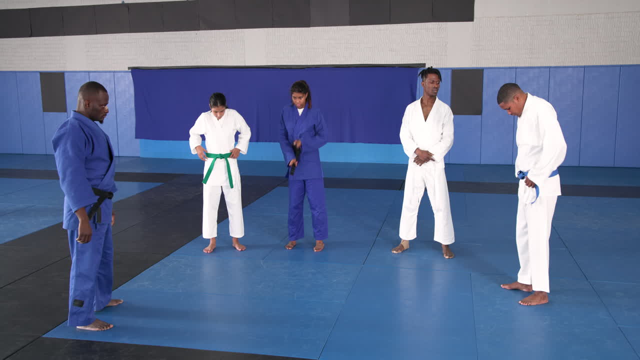 Practicing judo, group of athletes in martial arts uniforms on mat