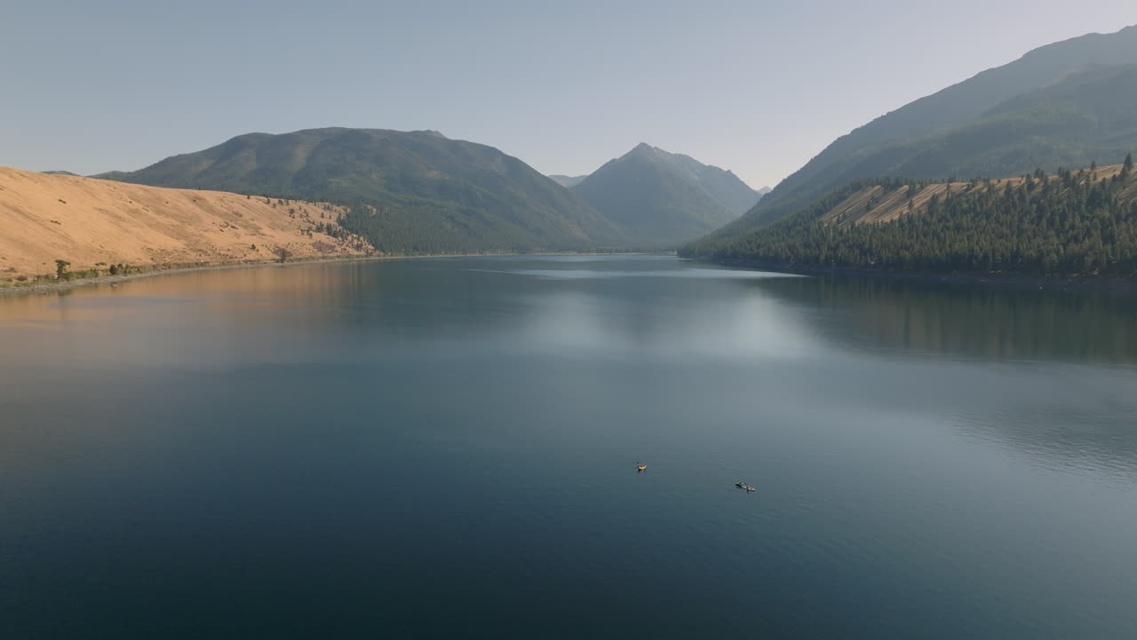 배경에 산이 있는 아름다운 호수에서 카약의 공중 전망