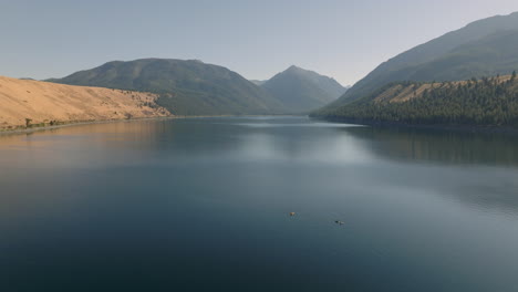 Aerial-view-of-kayaks-on-beautiful-lake-with-mountains-in-background