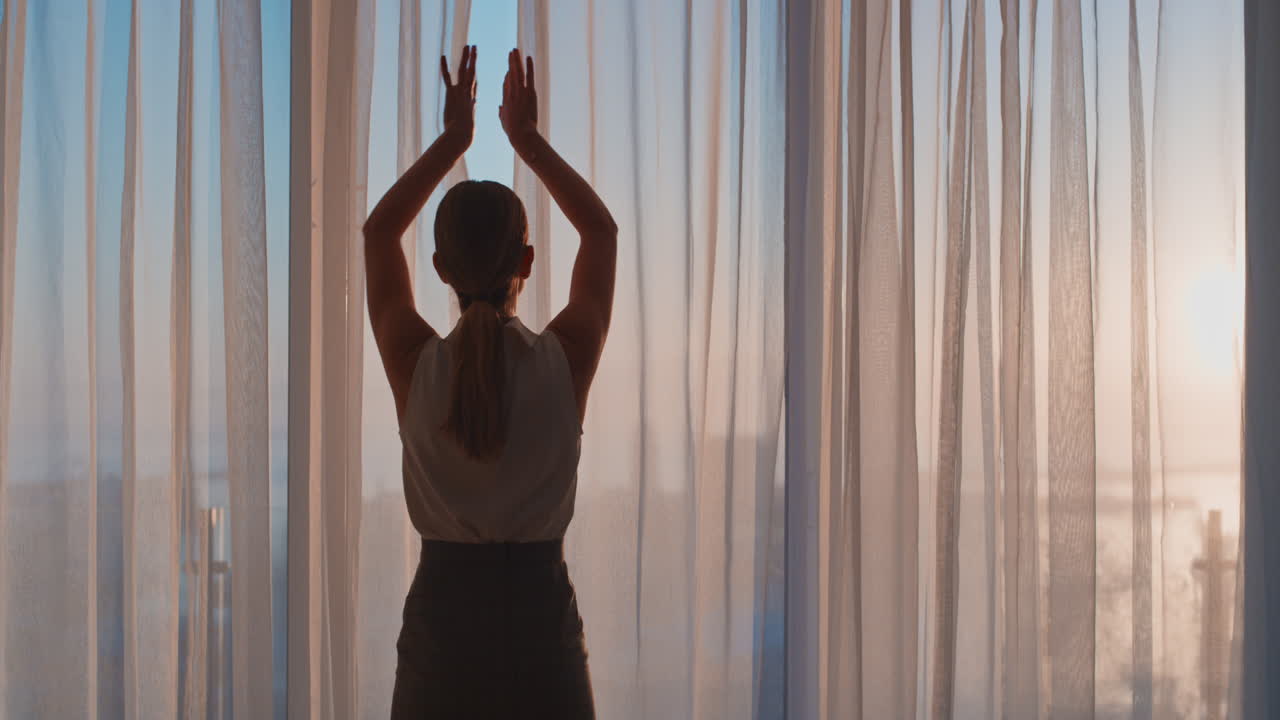 mujer de negocios abriendo cortinas en la habitación del hotel mirando por la ventana al fresco nuevo día exitosa mujer independiente planeando adelante al amanecer