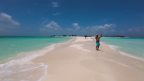 Man-barefoot-walks-aimlessly-on-sand-beach-take-selfie-photo-to-share-on-social-networks