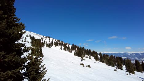 Person-skiing-down-slopes-at-Breckenridge-resort-on-beautiful-sunny-day