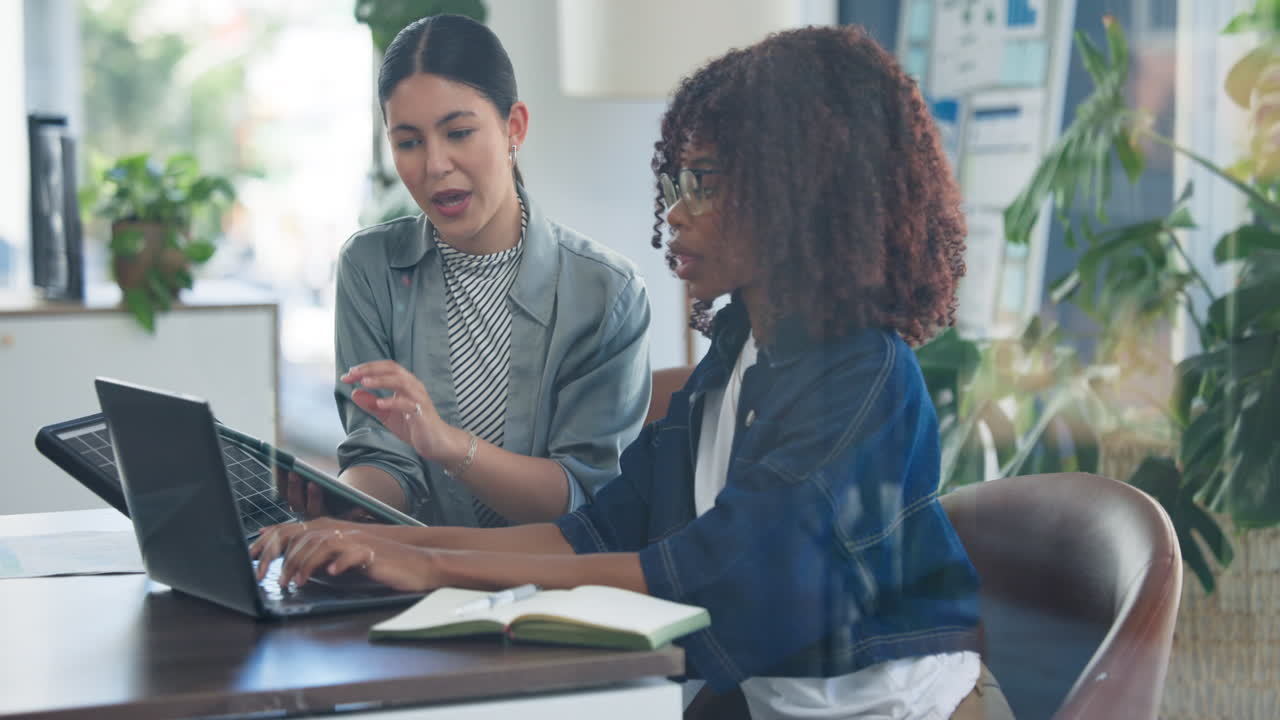 Diverse Businesswomen Collaborating on Laptop and Tablet in Modern Office