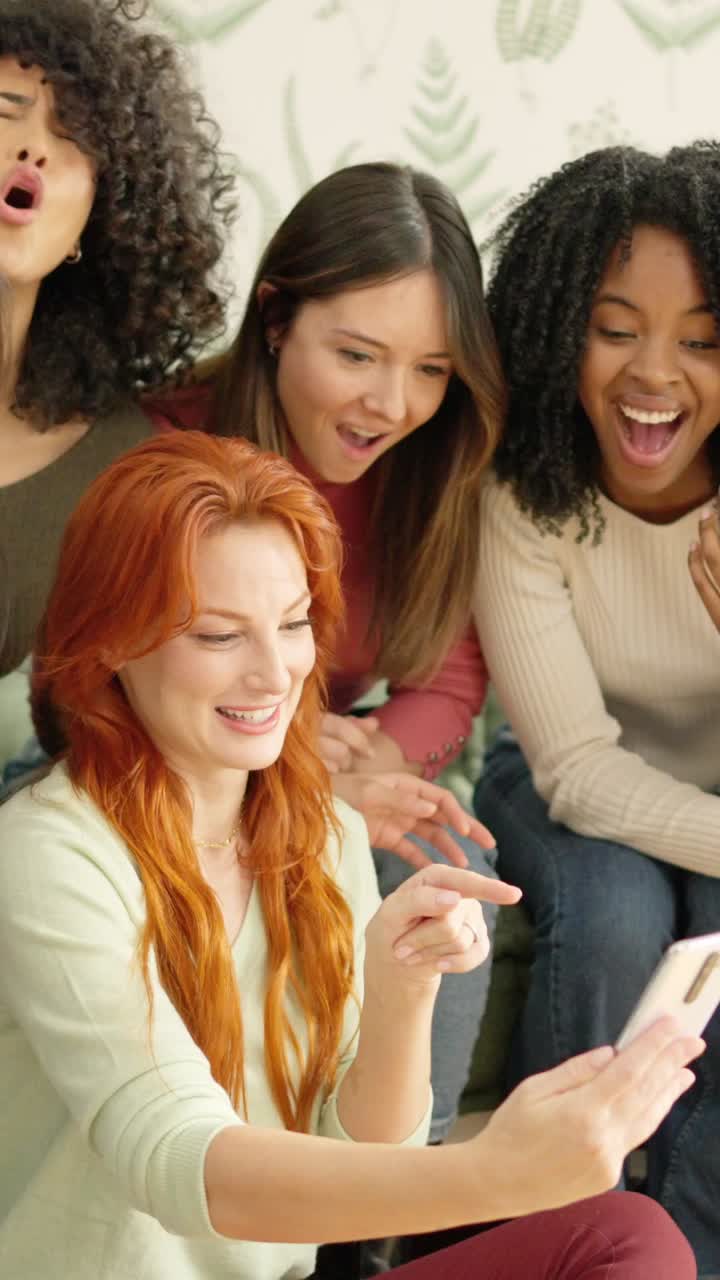 Girls looking at a mobile and laughing at one video