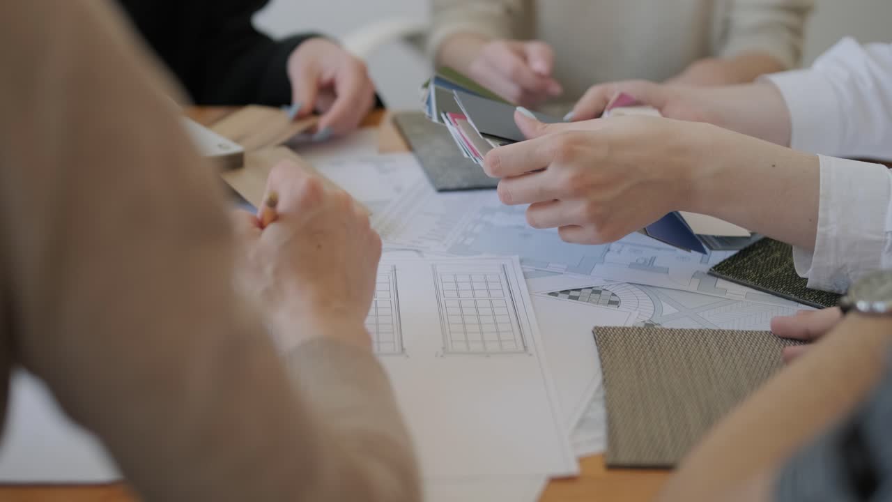 팀원들이 재료와 색을 선택하고, 바닥 계획을 상담하고, 인테리어 디자인 프로젝트에 대한 창의적인 의사 결정에 참여하는 협력 디자인 회의.