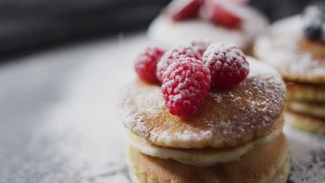 Video-of-pancakes-on-plate-seen-from-above-on-wooden-background