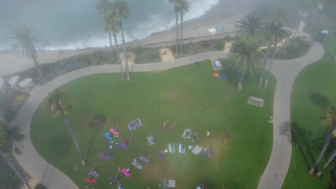 아침 안개의 하향식 공중 전망과 아침 운동을 하고 태평양 옆 공원에서 스트레칭을 하는 사람들, 라구나 비치 캘리포니아 미국, 높은 각도의 드론 샷