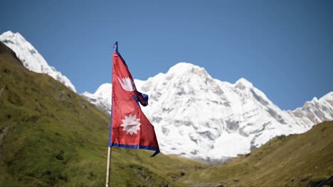 Nepal-Flag-and-Himalayas-Mountains,-Nepalese-Country-Flag-and-Big-Snowcapped-Mountains-with-Beautiful-Mountain-Scenery-and-Massive-Snowy-Summits-with-Flag-Blowing-in-the-Wind