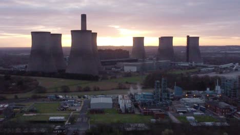 Luftaufnahme-über-Dem-Stillgelegten-Kohlekraftwerk-Fiddlers-Ferry-Mit-Sonnenaufgang,-Der-Hinter-Dem-Wahrzeichen-Leuchtet