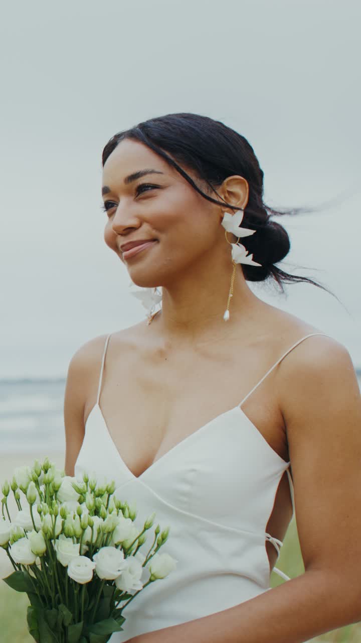 Una bellissima sposa sulla spiaggia con un bouquet di fiori