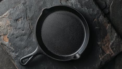 empty cast iron skillet on black background