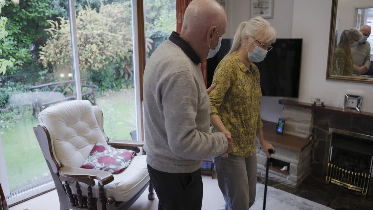 Elderly Couple Supporting Each Other at Home with Masks