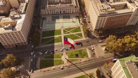 majestic 4k slow-motion (30fps) of the large bandera bicentenario (chilean bicentennial flag) waving over a busy avenue with city traffic in de chile.
