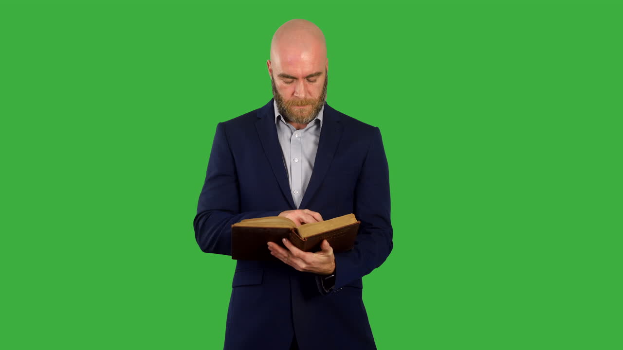 un hombre leyendo un libro o una biblia en pantalla verde