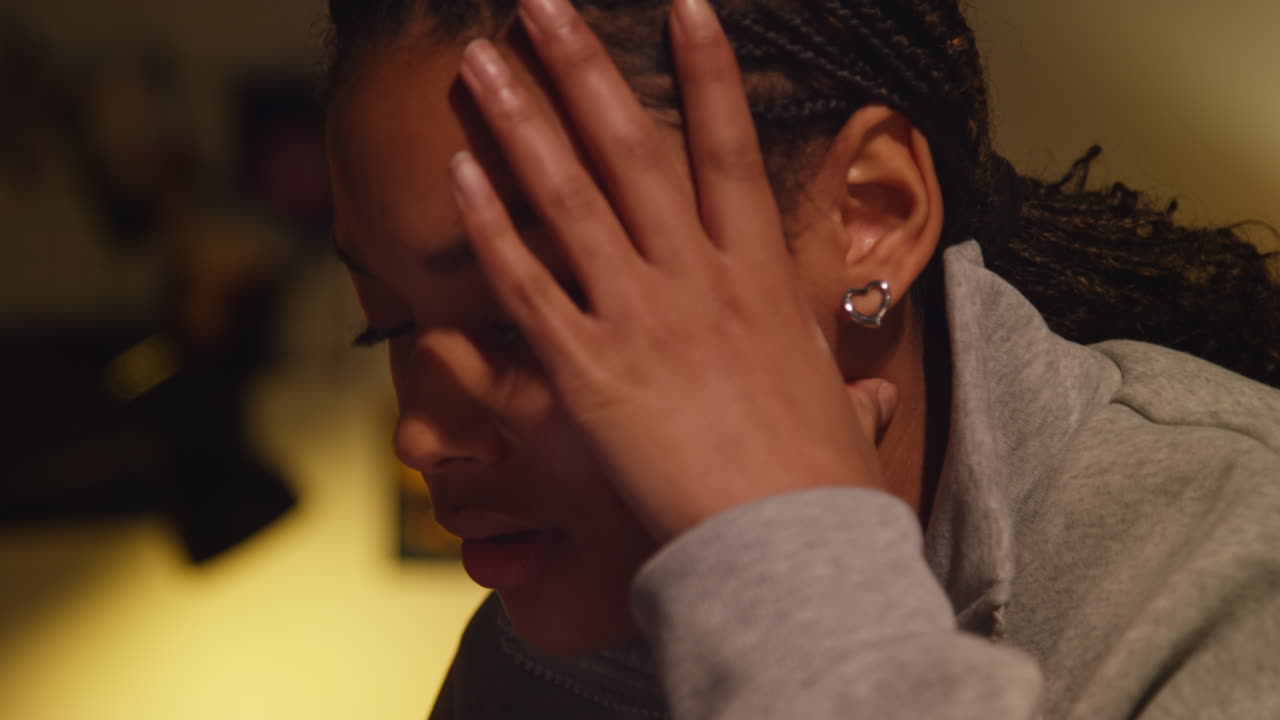 mujer con la mano en la cara, mirando triste