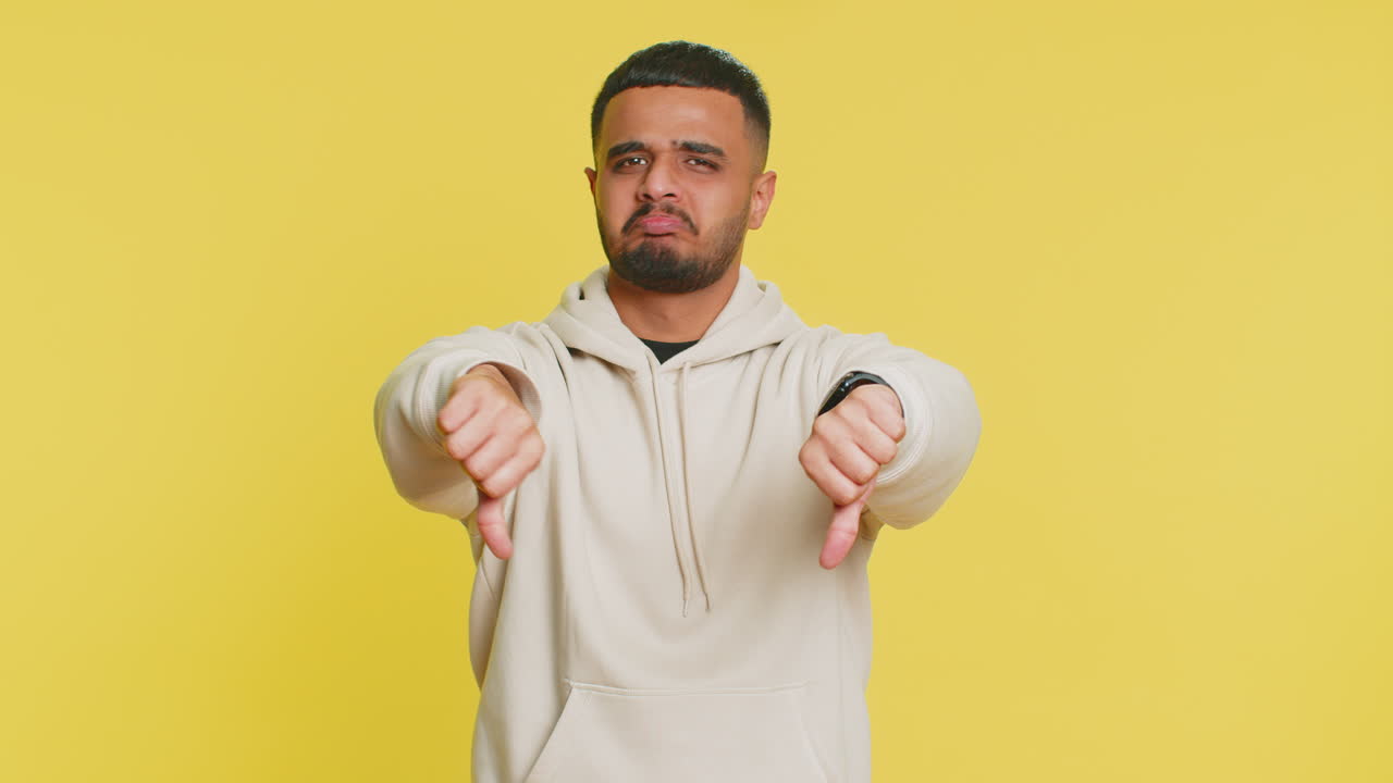 Uomo sconvolto ragazzo che mostra il pollice in giù gesto di disapprovazione insoddisfatto non piace feedback negativo