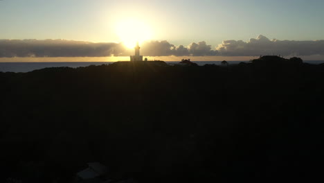 drone shot of the famous lighthouse during sunset at byron bay, australia.