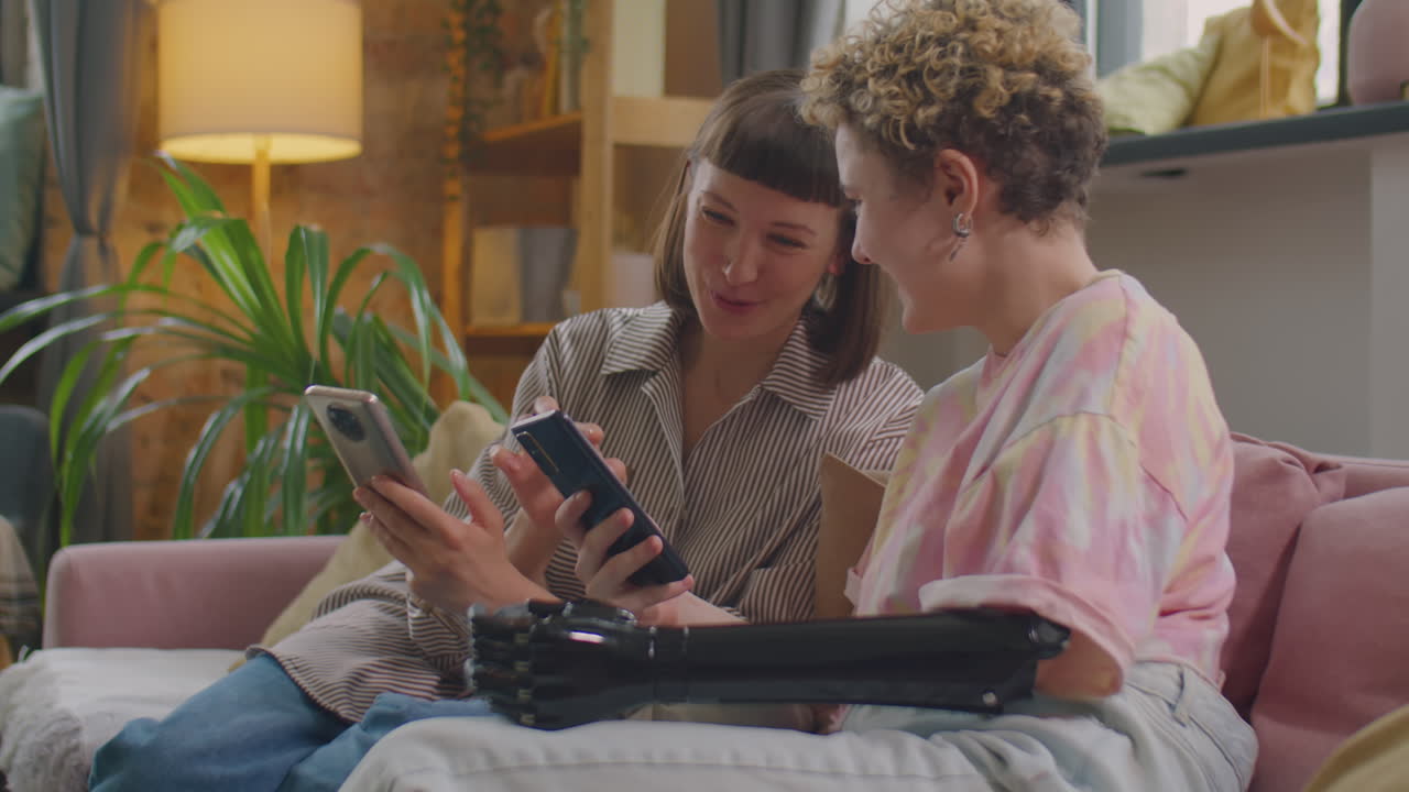 Girl with Prosthetic Arm Using Phone and Chatting with Friend