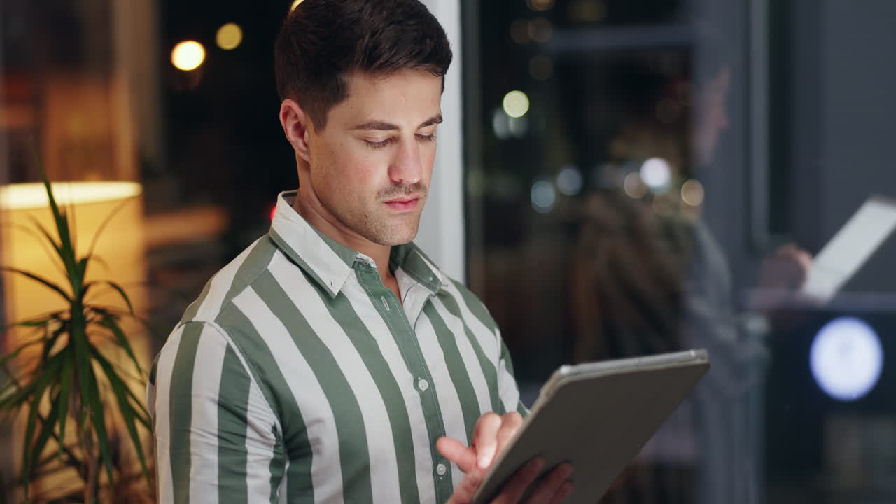 Man using tablet in office at night