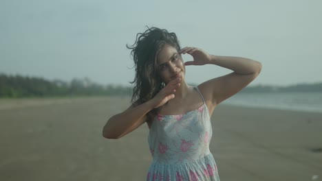 A-tourist-woman-is-standing-on-a-beach-with-her-hair-in-her-hands