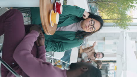 colegas multiétnicos hablando sobre café en una cafetería al aire libre