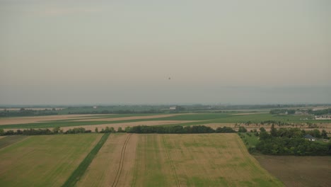 aerial view of a hot air balloon in the distance from a hot air balloon before sunrise in summer