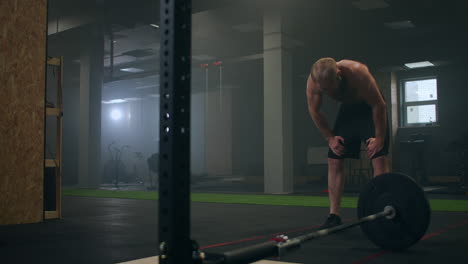 exhausted young men resting after intensive workout in gym. exhausted male athlete is resting after training. drops of water is draining from his face workout in gym