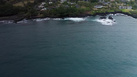Aerial low tilting up shot of Hana Bay and the small Hawaiian village of Hana Town on the slopes of Haleakala in Maui, Hawai&#039;i