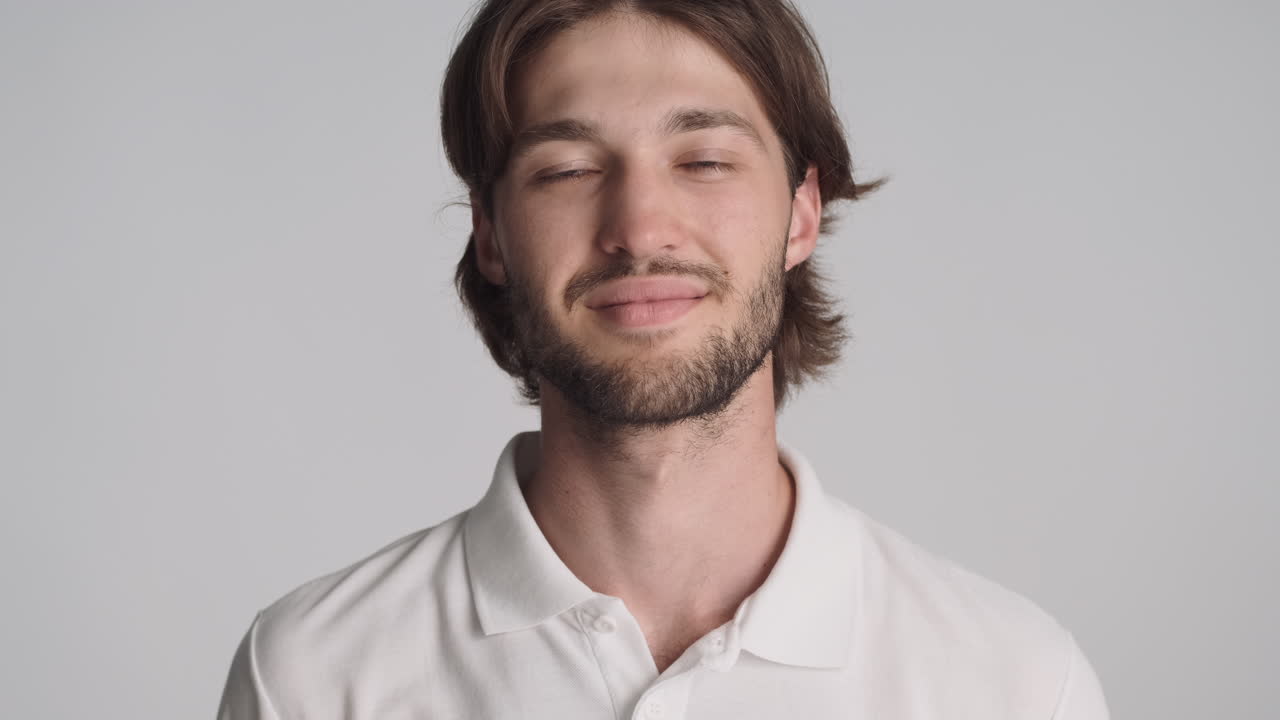 회색 배경에서 카메라 앞에 있는 백인 남자.