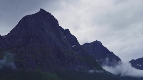 rocky mountains peak under cloudscape during misty morning at forest park in norway. - timelapse