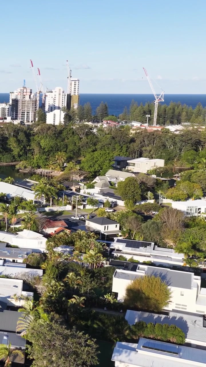 Ripresa aerea con drone di moderne case suburbane con lo skyline di Surfers Paradise in Australia.