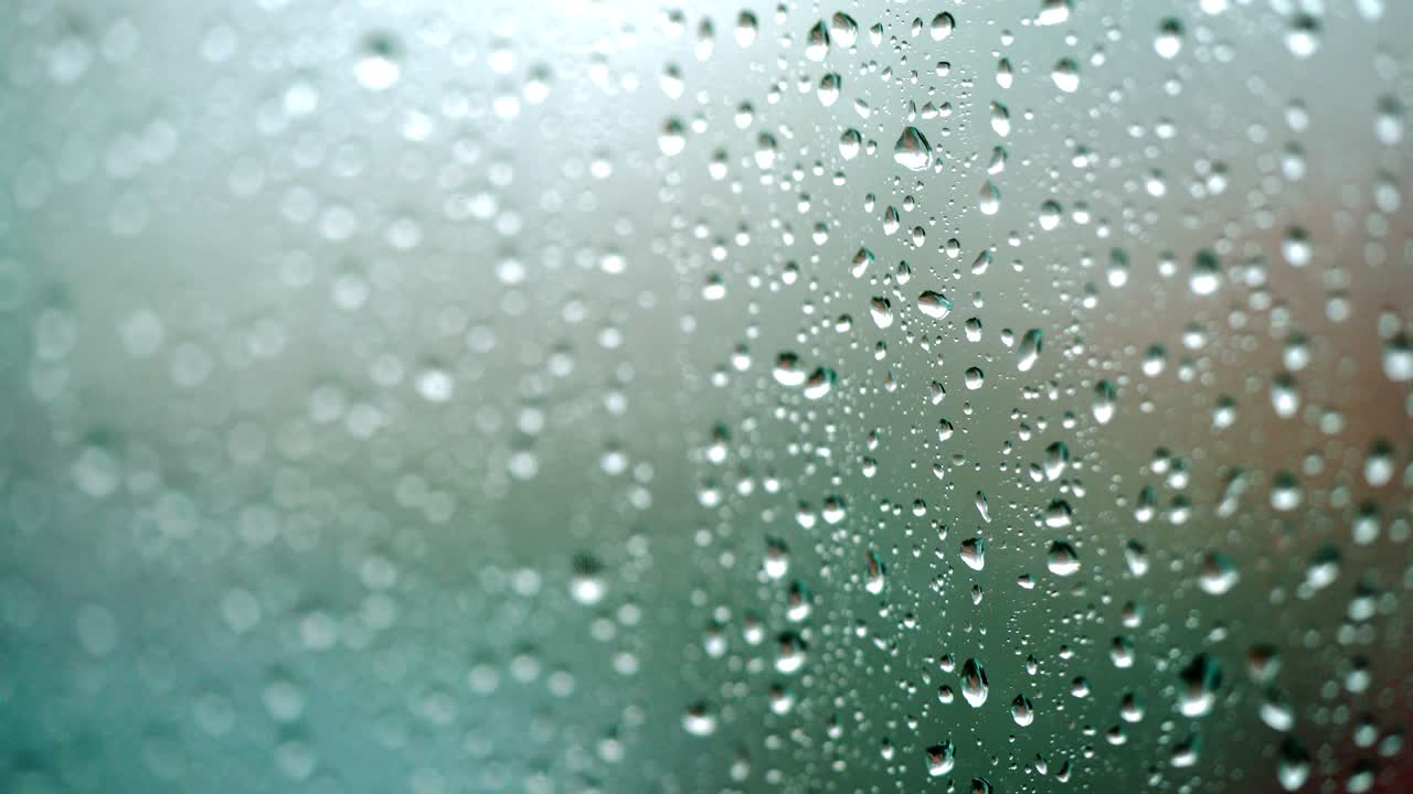 Rain falling on glass during rain storm.