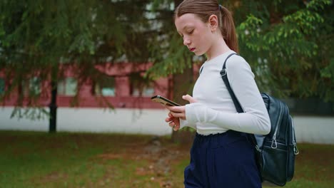 teenage girl using smartphone outdoors