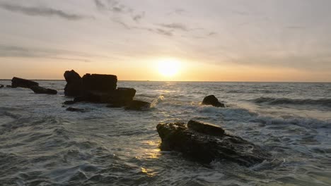 beautiful aerial establishing view of karosta concrete coast fortification ruins, vibrant sunset over stormy baltic sea, winter evening, slow motion drone dolly shot moving left