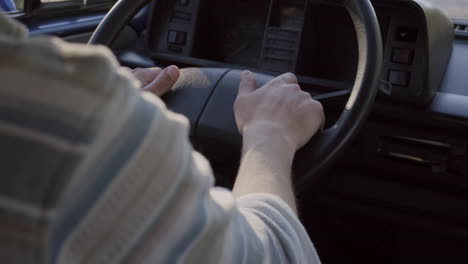 manos de un hombre que conducía una vieja caravana durante un viaje por carretera