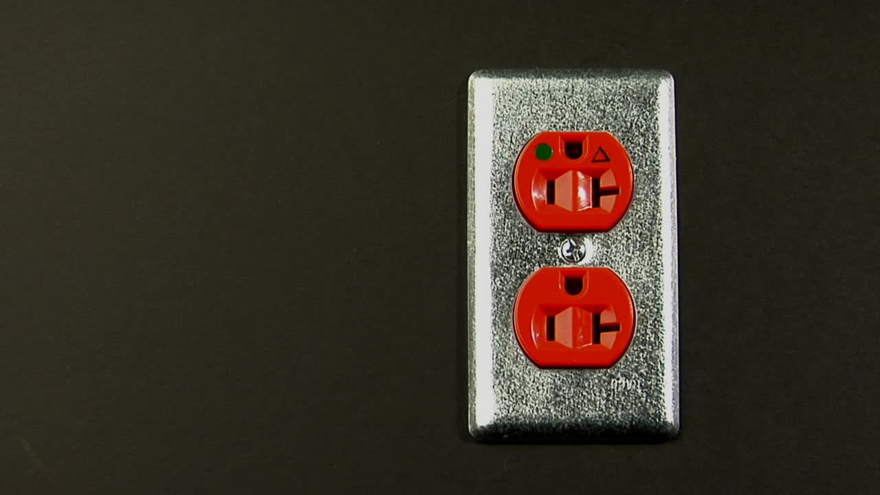 оранжевая электрическая розетка сидит в стене